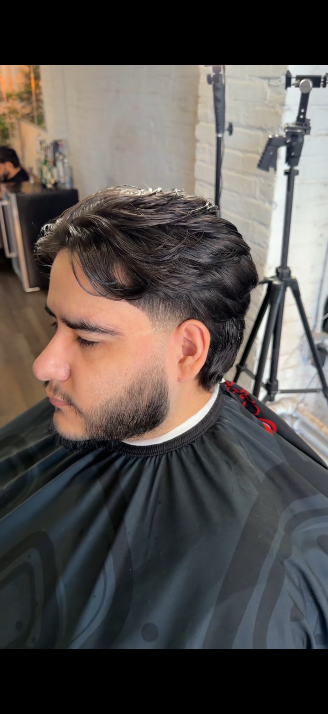 Cristian styling a client's haircut