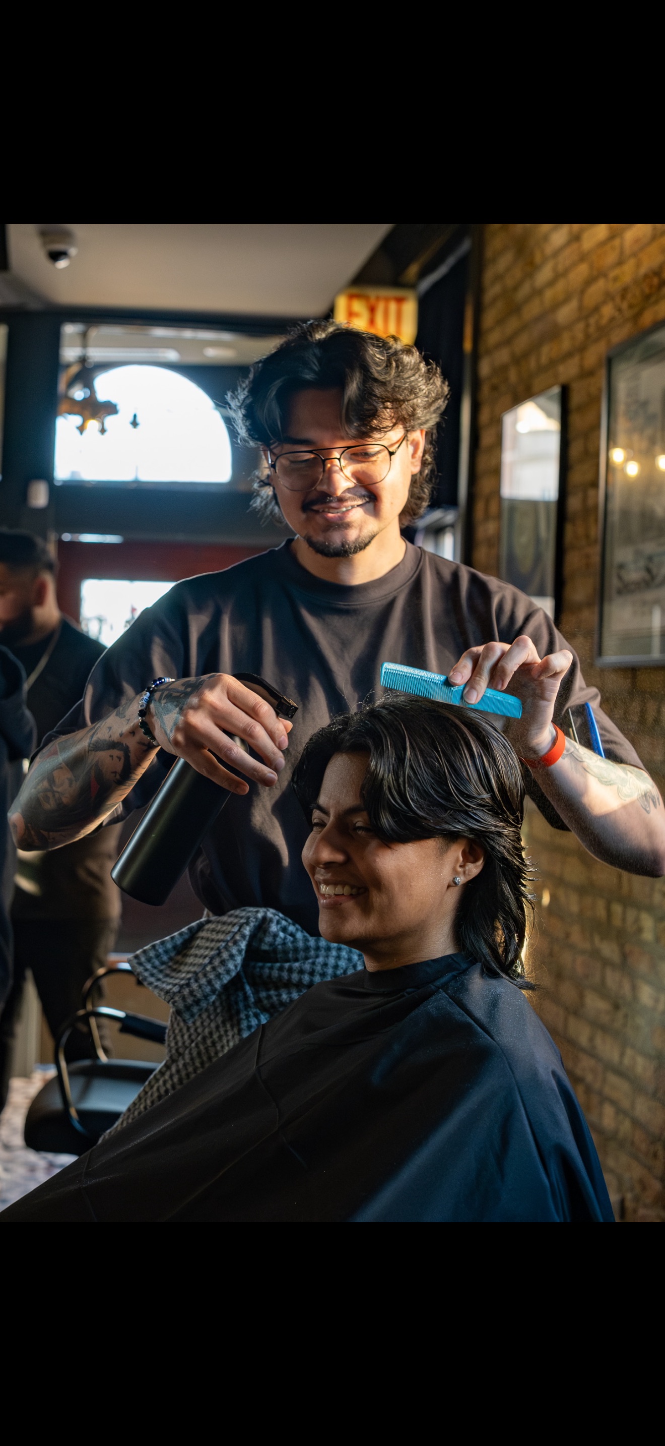 Cristian styling a client's blowout in the shop