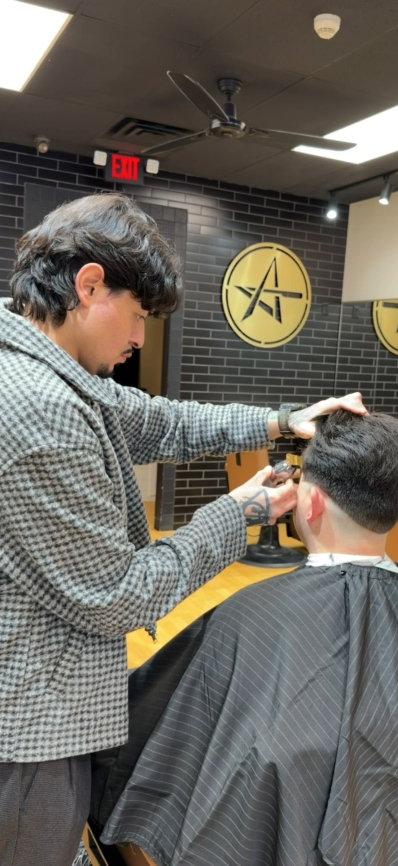 Cristian cutting a client's hair at the Plainfield shop