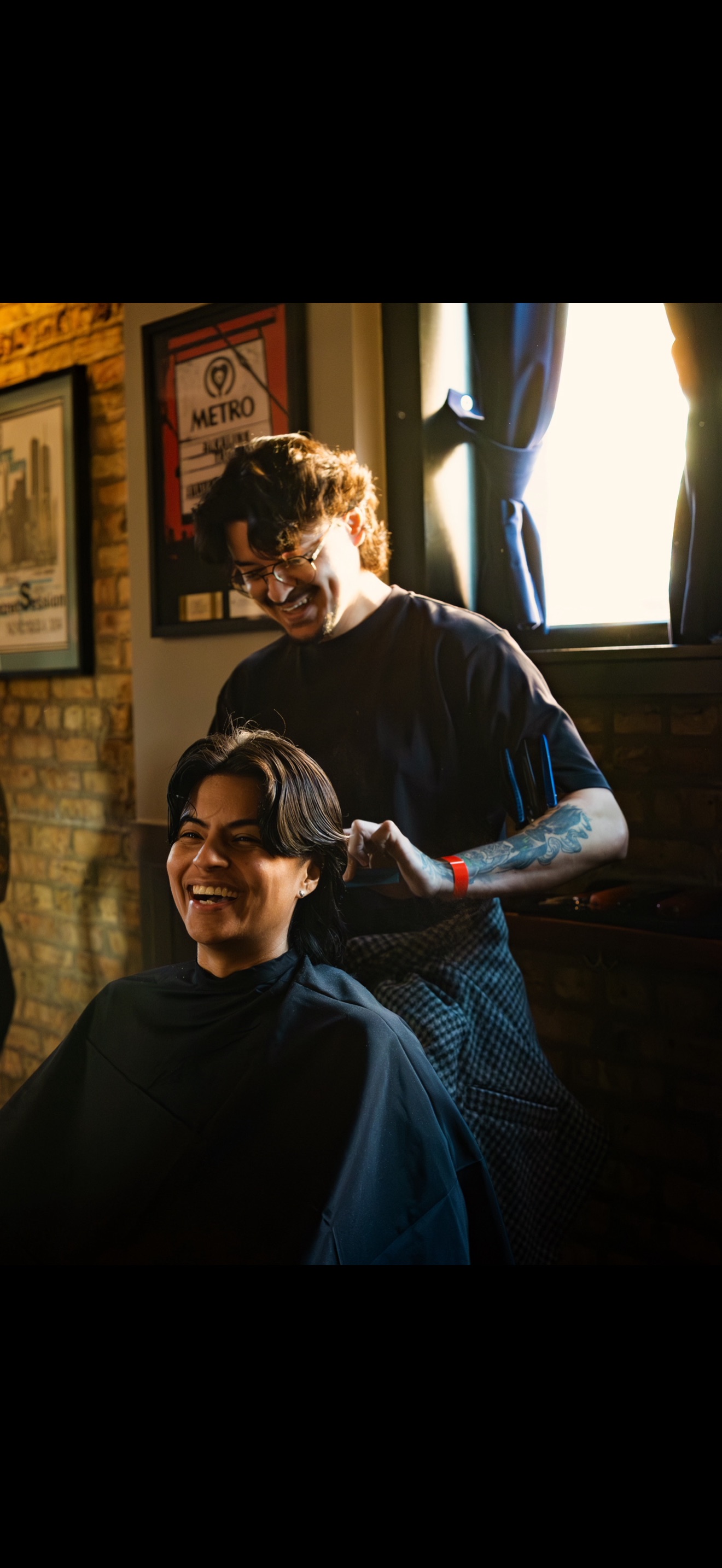 Cristian Salazar cutting a client's hair in the shop